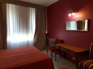 sypialnia z łóżkiem, biurkiem i oknem w obiekcie Hotel Tres Sargentos w BuenosAires