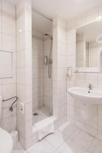 a white bathroom with a shower and a sink at Hotel Globus in Prague