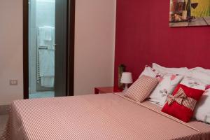 a bedroom with a bed with a red wall at LA CASA DI MAMMA 'NTO in Castrofilippo