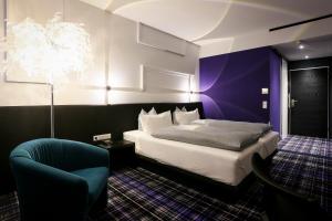 sypialnia z łóżkiem typu king-size i krzesłem w obiekcie Hotel Schempp w mieście Bobingen