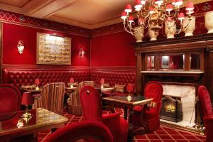 a restaurant with red chairs and a fireplace at Rubens At The Palace in London