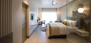 a hotel room with a bed and a glass wall at The Park Baga River Goa in Baga