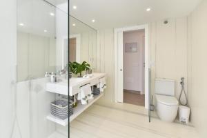 un bagno con un water, un lavandino e uno specchio di Maspalomas Beach apartment La Charca III by VillaGranCanaria a Maspalomas Altre 17 foto