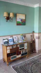 een kamer met een tafel en een tv aan de muur bij Hotel Cortijo in Laredo