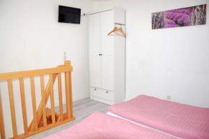 BlieschowFerienwohnung Anja的卧室配有粉红色的床和衣柜。