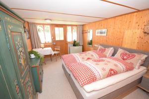 um quarto com uma cama com almofadas vermelhas e brancas em Studio bim Chalet bim Chilchli em Mürren