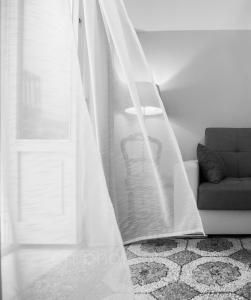 cortina blanca en la sala de estar con sofá en La Dimora del Falconiere - Luxury Suites, en Sulmona
