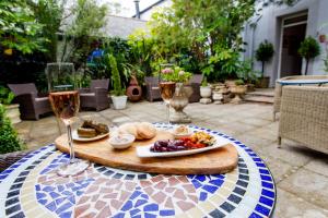 une table avec une assiette de nourriture et deux verres de vin dans l'établissement The Summer House, à Penzance