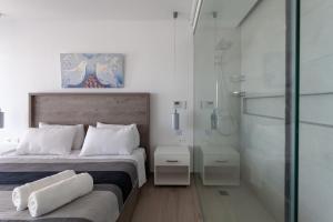 a bedroom with a shower and a bed with white pillows at Villa Faros in vlicha