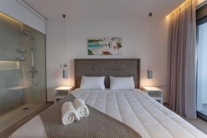 a bedroom with a large bed with towels on it at Villa Faros in vlicha