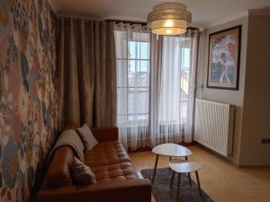 salon z kanapą i oknem w obiekcie Minaret Apartman w Egerze