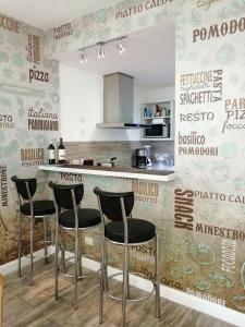 a kitchen with a bar with stools in front of a wall at star apartment olivos in Olivos