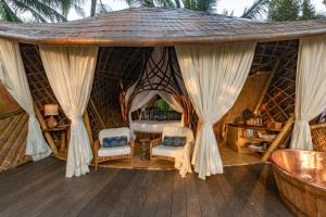 a room with a bed and two chairs in a tent at Stone House in Ubud