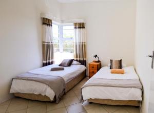 two beds in a room with a window at Sundaze Riverside House - Colchester - 5km from Elephant Park in Colchester