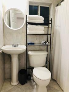 ein Badezimmer mit einem WC, einem Waschbecken und einem Spiegel in der Unterkunft The Heart of Wynwood in Miami