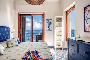 a bedroom with a bed with a view of the ocean at RELAIS TRITONE in Nerano