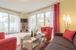 a living room with red chairs and a table at Ferienhaus Rotmilan in Vieregge