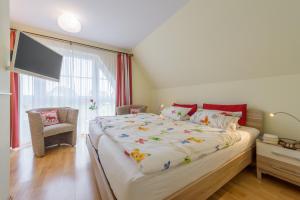 a bedroom with a large bed and a television at Ferienhaus Rotmilan in Vieregge