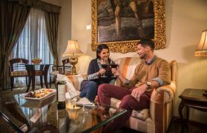 
a man and a woman sitting on a couch in a living room at Aranwa Cusco Boutique Hotel in Cusco
