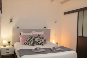 1 dormitorio con 1 cama con 2 toallas en Le Paquier - Avec Balnéo - Au Cœur d'Annecy - Majord'Home, en Annecy