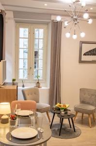 sala de estar con mesa, sillas y lámpara de araña en Le Paquier - Avec Balnéo - Au Cœur d'Annecy - Majord'Home en Annecy