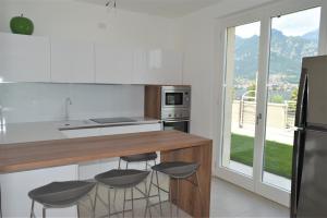 a kitchen with a counter and stools in it at Villa Mimosa Bellagio Wild Flowers in Oliveto Lario