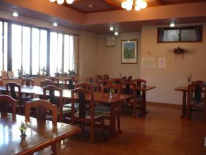 a dining room with tables and chairs and windows at Oyado Nozawaya in Nozawa Onsen