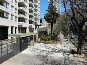 a sidewalk in front of a large apartment building at star apartment olivos in Olivos