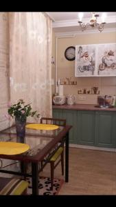 ポルタヴァにあるApartment na Zenkovskoiのキッチン(テーブル、黄色い椅子、カウンター付)