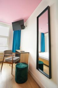 Cette chambre comprend un miroir, une chaise et un lit. dans l'établissement Sparks Hostel, à Rotterdam