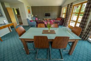 - un salon avec une table et des chaises dans l'établissement Loch Lomond Waterfront Luxury Lodges, à Balmaha