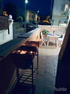 a bar on a balcony at night with a table at La Terrazza sul Golfo in Golfo Aranci