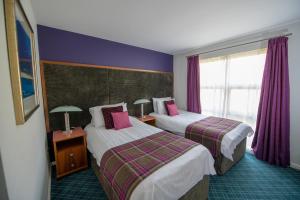 
A bed or beds in a room at Loch Lomond Waterfront Luxury Lodges

