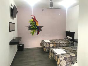 Habitación con 2 camas y un loro en la pared en HOTEL LOS PINOS CENTRO en Tuxtla Gutiérrez