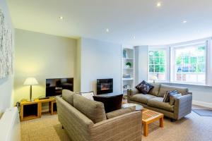a living room with two couches and a tv at Luxury Apartments - 22 Garden Flat in Cheltenham