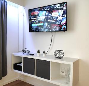 einen TV an der Wand mit einem weißen Entertainment-Center in der Unterkunft Gemütliches Apartment mit WLAN in ruhiger Lage! in Dielmissen