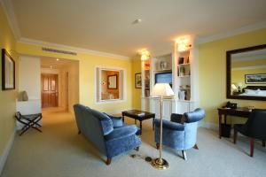 a living room with two blue chairs and a mirror at The Yeatman in Vila Nova de Gaia