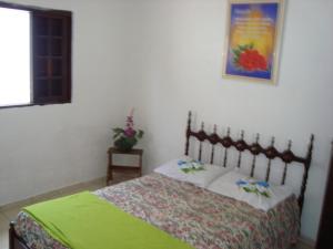 een slaapkamer met een bed en een foto aan de muur bij Casa arejada e espaçosa in Bertioga