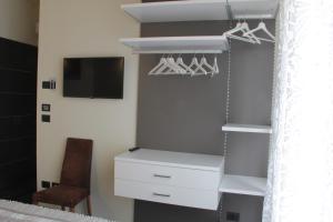 a bedroom with a closet with a dresser and a tv at Villa Mirella in Bordighera