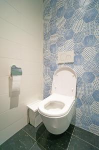 uma casa de banho com um WC com azulejos azuis e brancos em Sparks Hostel em Roterdã