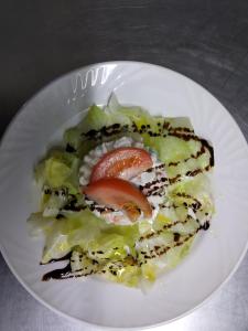 um prato branco com uma salada com um tomate em Guara-Altaoja-Yaso em Yaso