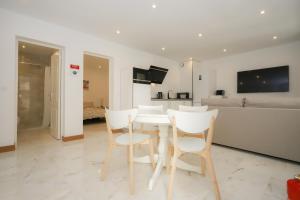 une salle à manger blanche avec des chaises blanches et une table dans l'établissement Apartamento Casino Praia III, à Figueira da Foz
