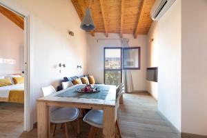 a dining room with a table and chairs and a bed at ecoGrusApartments in El Masnou