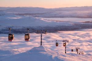 um grupo de teleféricos no topo de uma montanha coberta de neve em Åre Torg Hotell em Åre