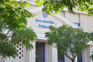 a blue building with a sign on the front of it at Apartamentos Luxsevilla Palacio in Seville