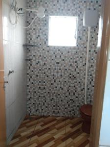 a bathroom with a shower with a toilet and a window at Casa Nascer do Sol in São Thomé das Letras