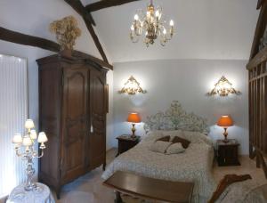 1 dormitorio con cama y lámpara de araña en Le Relais de la Tour, en La Chaussée-Saint-Victor