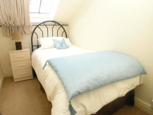 a bedroom with a bed with a blue pillow on it at Juliet Cottage HOT TUB Sleeps 3 Singles or Double in Stratford-upon-Avon