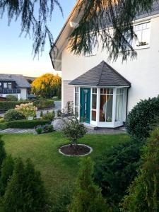 a white house with a blue door and a yard at An den Bergwiesen in Winterberg