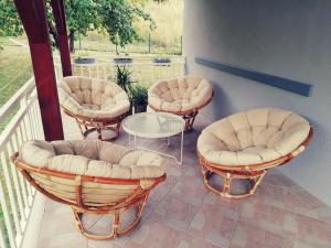 three chairs and a table on a balcony at Artisan House Meraki in Udbina